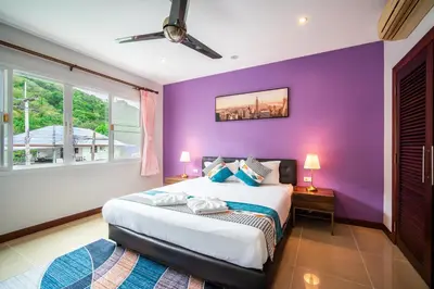 a purple bedroom with a bed and two windows at \u82ad\u4e1cvilla3\u56db\u5367\u6d77\u666f\u6cf3\u6c60\u522b\u5885\u82ad\u4e1c\u6d77\u6ee9\u8fd1\u73ed\u8d5eBangla in Patong Beach
