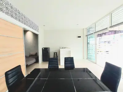 a dining room with a black table and chairs at Room Phuket Town by Alissa in Ban Phlu Yai