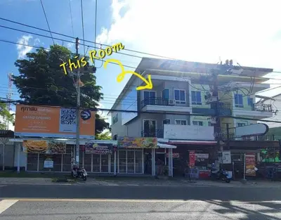 a building with a yellow sign in front of it at Room Phuket Town by Alissa in Ban Phlu Yai