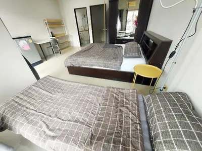 a room with two beds and a tv in it at Room Phuket Town by Alissa in Ban Phlu Yai