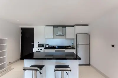 a kitchen with white cabinets and black counter tops at Nakalay Palm by Thaire in Kamala Beach