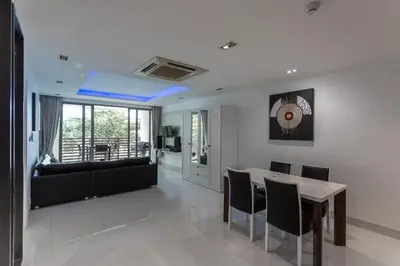 a living room with a table and a couch at Nakalay Palm by Thaire in Kamala Beach