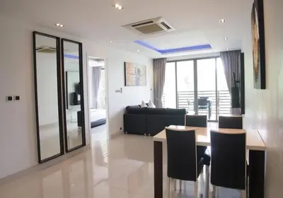 a living room with a table and a couch at Nakalay Palm by Thaire in Kamala Beach