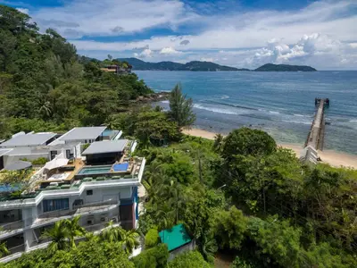 a building on a hill next to a beach at Nakalay Palm by Thaire in Kamala Beach