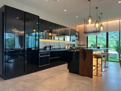 a kitchen with black cabinets and a bar in it at Karon Beach Residence in Karon Beach