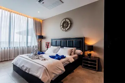 a bedroom with a large bed with a clock on the wall at Karon Beach Residence in Karon Beach