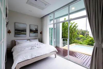 a bedroom with a bed and a large window at Karon Beach Residence in Karon Beach