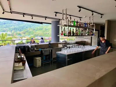 a man standing behind a bar with wine glasses at Junior Suite D37 Kamala Beach in Kamala Beach