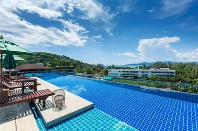 a large swimming pool with chairs and an umbrella at Aristo Resort M08 Surin Beach in Surin Beach