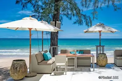 a table and chairs and umbrellas on the beach at Aristo Resort M08 Surin Beach in Surin Beach
