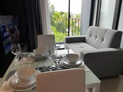 a living room with a table and a couch at Aristo Resort M08 Surin Beach in Surin Beach