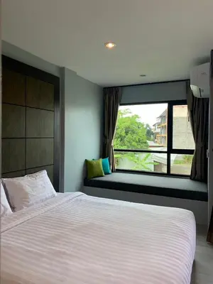 a bedroom with a large bed and a window at Afiyath Residence in Kamala Beach