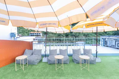 a group of chairs and umbrellas on a deck at Mellow Poshtel - Kata Beach in Kata Beach