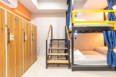 a dorm room with bunk beds and a staircase at Mellow Poshtel - Kata Beach in Kata Beach