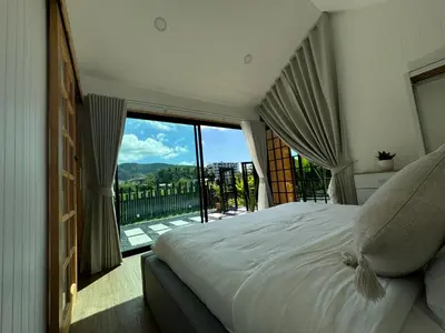 a bedroom with a large bed and a large window at Sea Salt Casa Bang Tao in Ban Thalat Choeng Thale