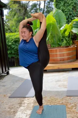 a woman doing a yoga pose on a yoga mat at Sea Salt Casa Bang Tao in Ban Thalat Choeng Thale