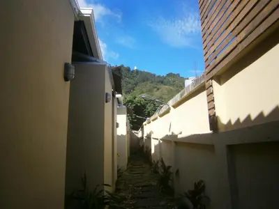 an alley between two buildings with a hill in the background at Infinity Boutique Hotel Kata Beach in Kata Beach