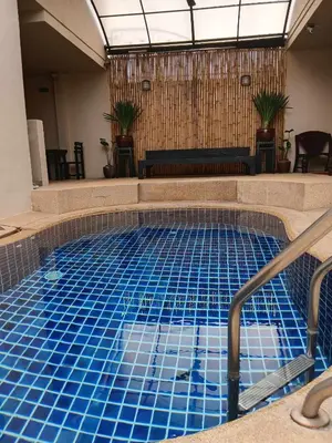 a swimming pool with blue tiles in a building at Infinity Boutique Hotel Kata Beach in Kata Beach