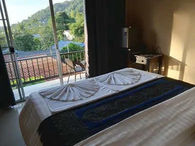 a bed in a room with a large window at Infinity Boutique Hotel Kata Beach in Kata Beach