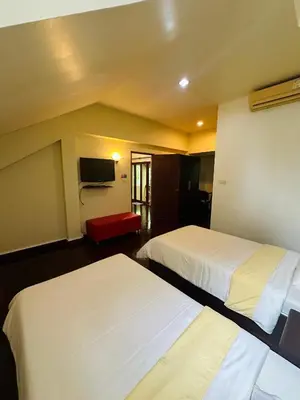 a hotel room with two beds and a tv at Patong Beach\u68ee\u6797\u5c4b111 in Patong Beach