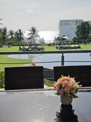 a vase of flowers sitting on a table near a pool at Karon Beach Large 2 bedrooms & living room Seaview apartment in Karon Beach