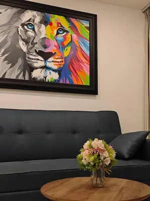 a painting of a lion and a table with flowers at Karon Beach Large 2 bedrooms & living room Seaview apartment in Karon Beach