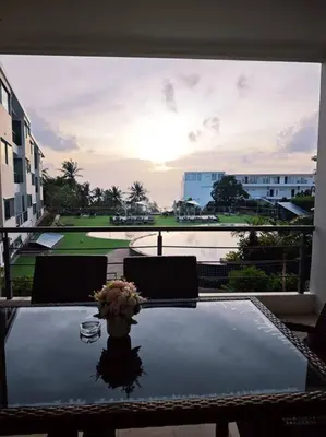 a table with a vase of flowers on top at Karon Beach Large 2 bedrooms & living room Seaview apartment in Karon Beach