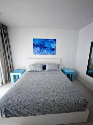 a bedroom with a bed and two blue tables at Karon Beach Large 2 bedrooms & living room Seaview apartment in Karon Beach