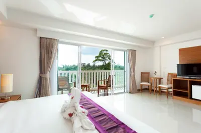 a hotel room with a bed and a balcony at Rawai Princess Hotel in Rawai Beach