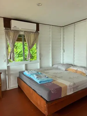 a large bed in a room with a window at ThaKhaopierBangalow in Ban Bang Chak