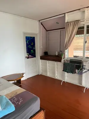 a bedroom with a bed and a window and a table at ThaKhaopierBangalow in Ban Bang Chak