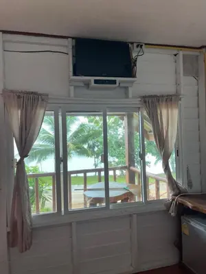 a room with a window with a television and a table at ThaKhaopierBangalow in Ban Bang Chak