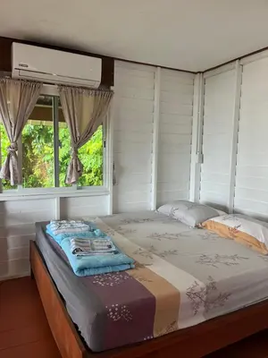 a large bed in a room with a window at ThaKhaopierBangalow in Ban Bang Chak