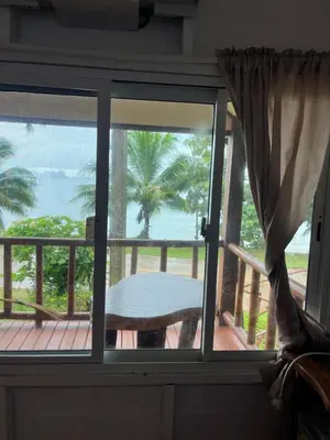 a window with a view of the ocean from a porch at ThaKhaopierBangalow in Ban Bang Chak