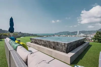 a swimming pool with a stone wall and a couch at \u84dd\u8272\u82ad\u4e1c\u8c6a\u534e5\u5367\u6d77\u666f\u522b\u5885 in Patong Beach