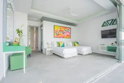 a white room with a bed and a painting on the wall at \u84dd\u8272\u82ad\u4e1c\u8c6a\u534e5\u5367\u6d77\u666f\u522b\u5885 in Patong Beach
