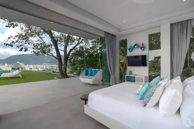 a bedroom with a bed and a large window at \u84dd\u8272\u82ad\u4e1c\u8c6a\u534e5\u5367\u6d77\u666f\u522b\u5885 in Patong Beach