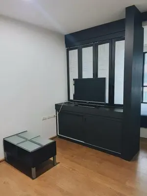 a living room with a tv and a black entertainment center at 38Nice room phuket town near Shopping Malls and Naka night market in Phuket Town