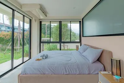 a bedroom with a bed and a large window at ANDAMAN Villa KOH YAO NOI in Ko Yao Noi
