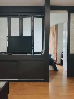 a living room with a flat screen tv on a entertainment center at 02Nice room phuket town near Shopping Malls and Naka night market in Phuket Town