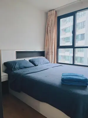 a bed with a blue blanket on it in a bedroom at 02Nice room phuket town near Shopping Malls and Naka night market in Phuket Town