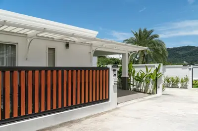 a white house with a fence and a gate at Friendly Kamala Garden View in Kamala Beach