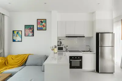 a kitchen with a couch and a stainless steel refrigerator at Friendly Kamala Garden View in Kamala Beach