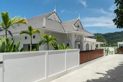 a white house with a fence at Friendly Kamala Garden View in Kamala Beach