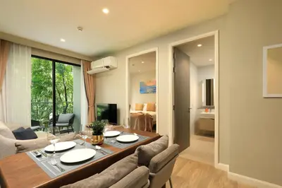 a dining room and living room with a table and chairs at Apartment 2 BDR Bangtao #2206 in Phuket