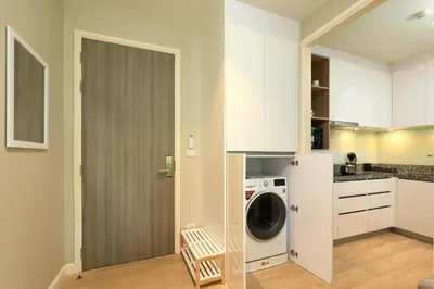 a kitchen with a washer and dryer next to a door at Apartment 2 BDR Bangtao #2206 in Phuket