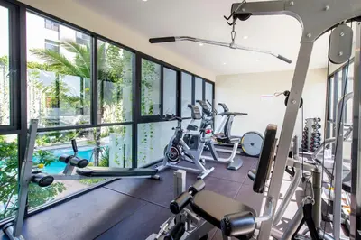 an indoor gym with treadmills and elliptical machines at Apartment 2 BDR Bangtao #2206 in Phuket