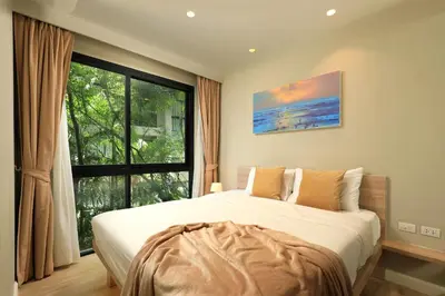 a bedroom with a large bed and a large window at Apartment 2 BDR Bangtao #2206 in Phuket