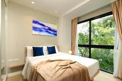 a bedroom with a bed and a large window at Apartment 2 BDR Bangtao #2206 in Phuket
