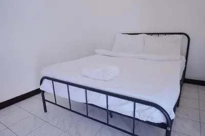 a bed with white sheets and pillows on it at XX GO INN Patong Beach หาดป่าตอง in Patong Beach